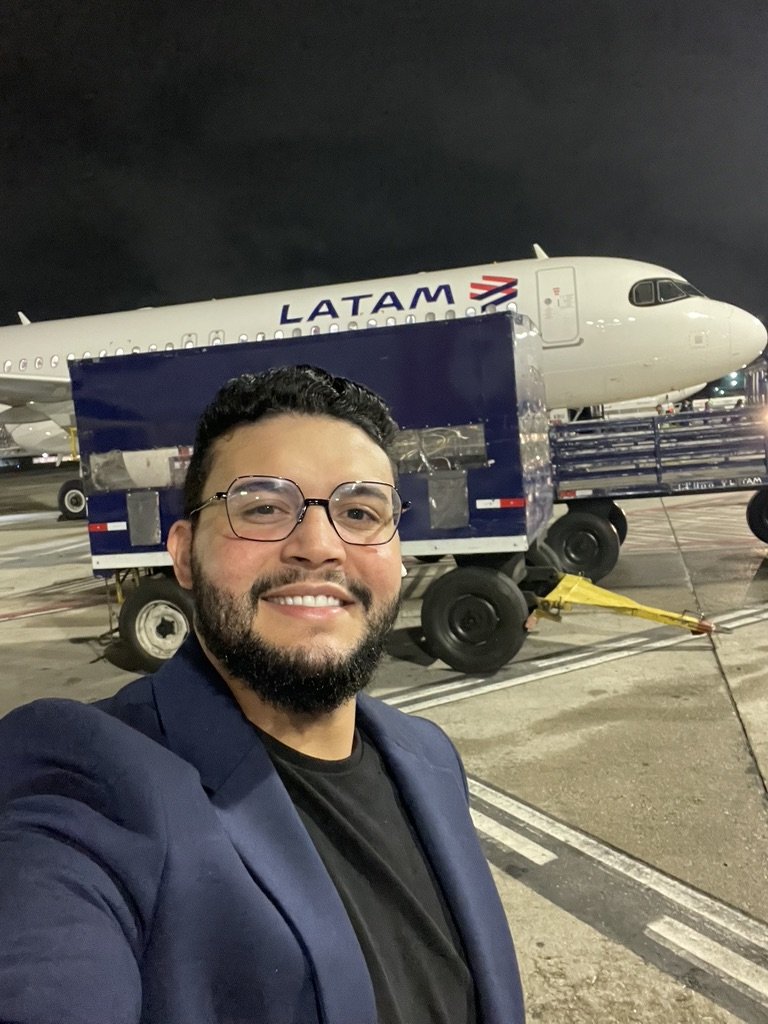 Gabriel de Freitas Carvalho smiling in a navy blazer and glasses, photographed outdoors at night