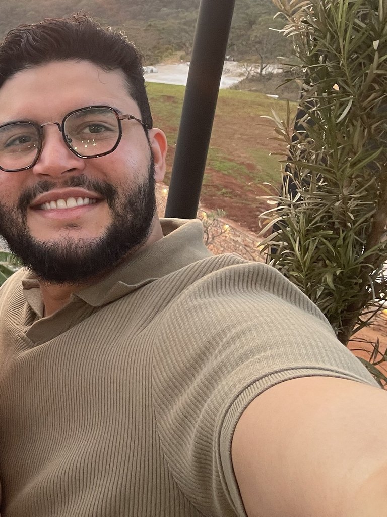Gabriel de Freitas Carvalho smiling outdoors in a beige polo shirt and glasses